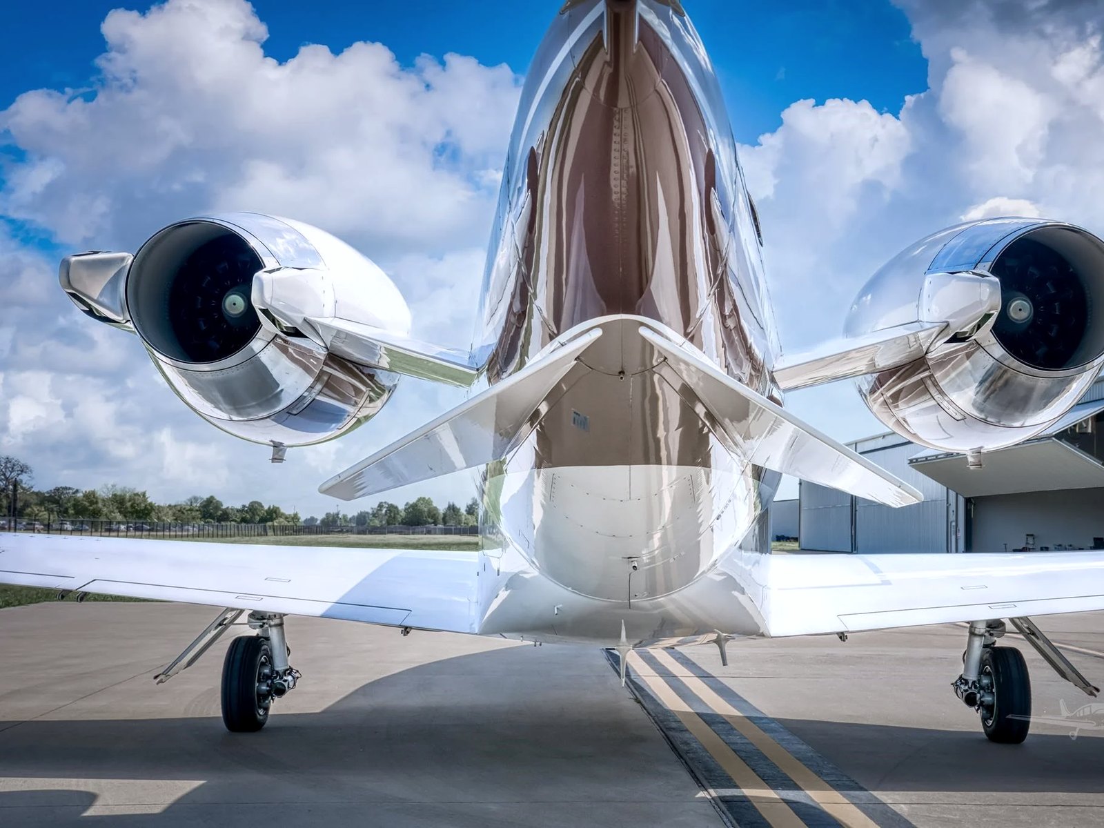 Rear three-quarter view of a private jet polished to a mirror finish